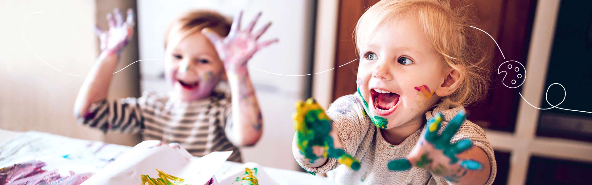 Two little kids enjoying the messy fun of hand painting.