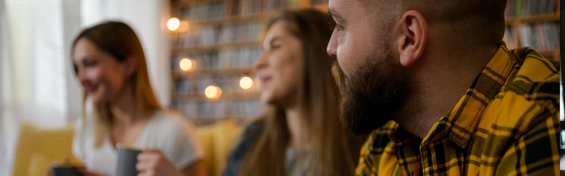 3 young adults are listening to something out of the frame