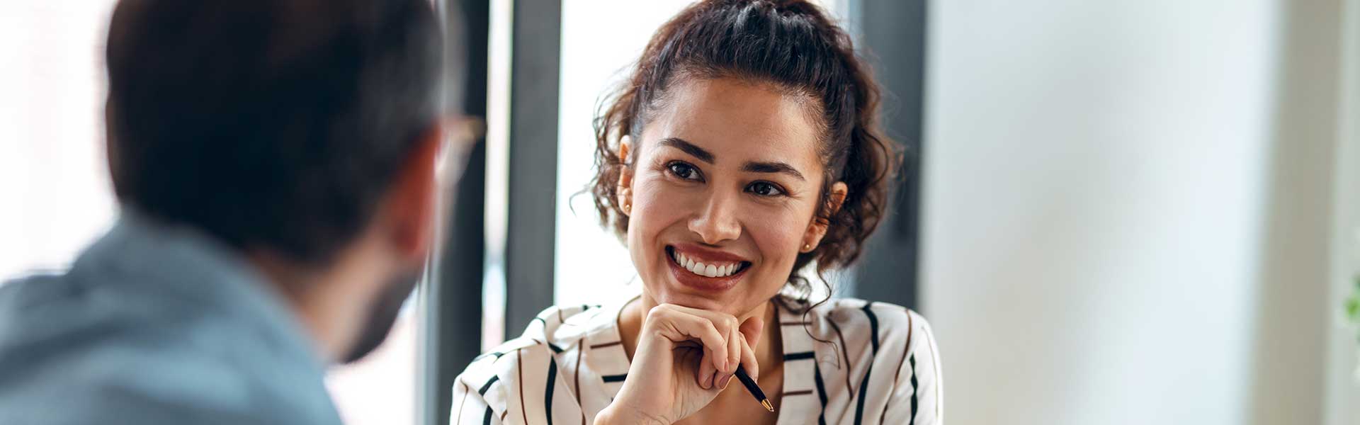 A woman smiles at her coworker as they work together on a project.